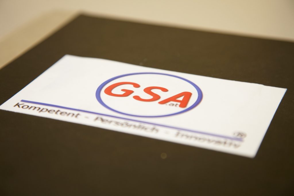 Karte mit dem GSA-Logo und dem Schriftzug „Kompetent – Persönlich – Innovativ“ auf einem Schreibtisch